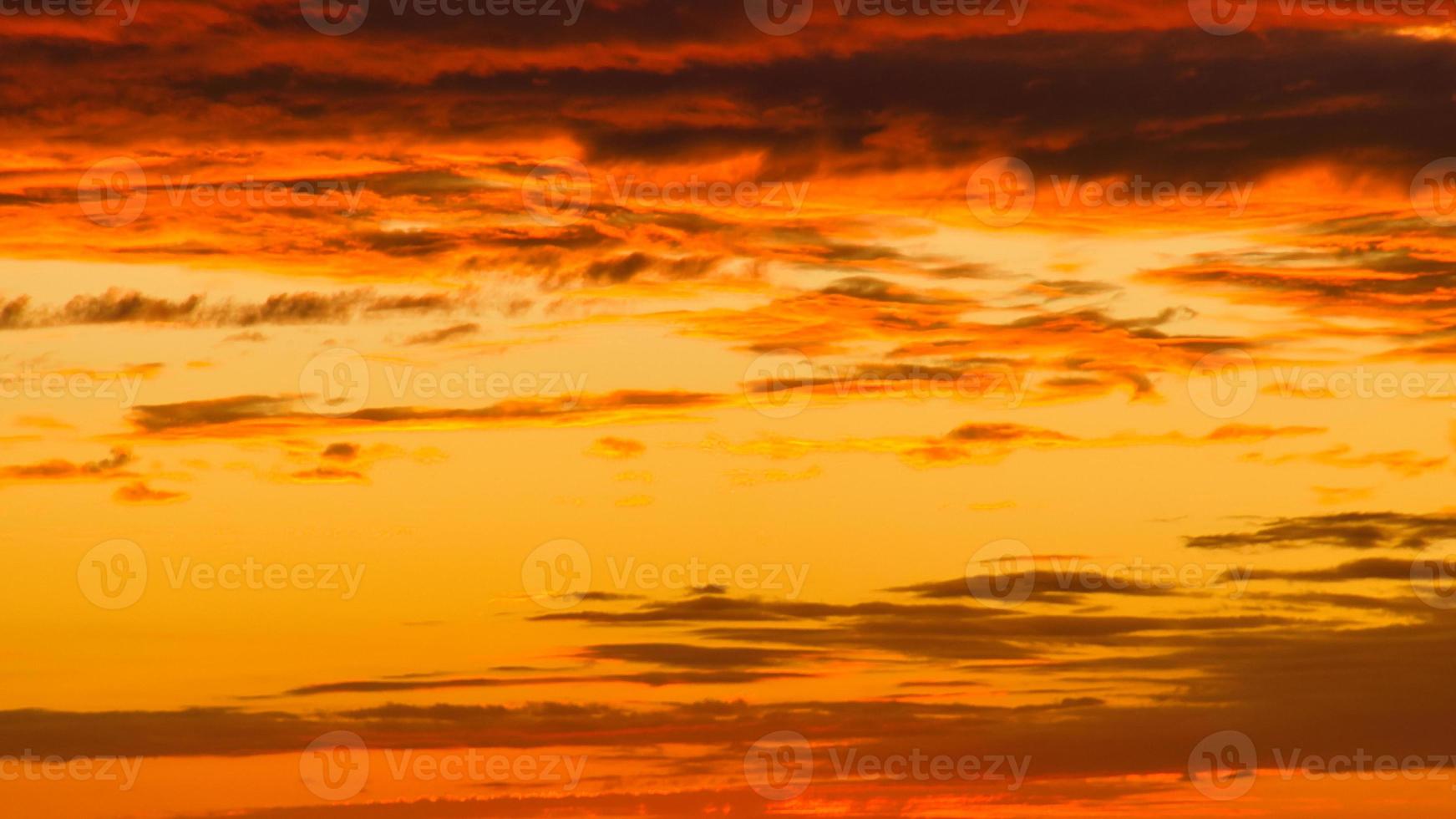 Background image with clouds in extreme colors of a sunset. The sky seems to burn photo