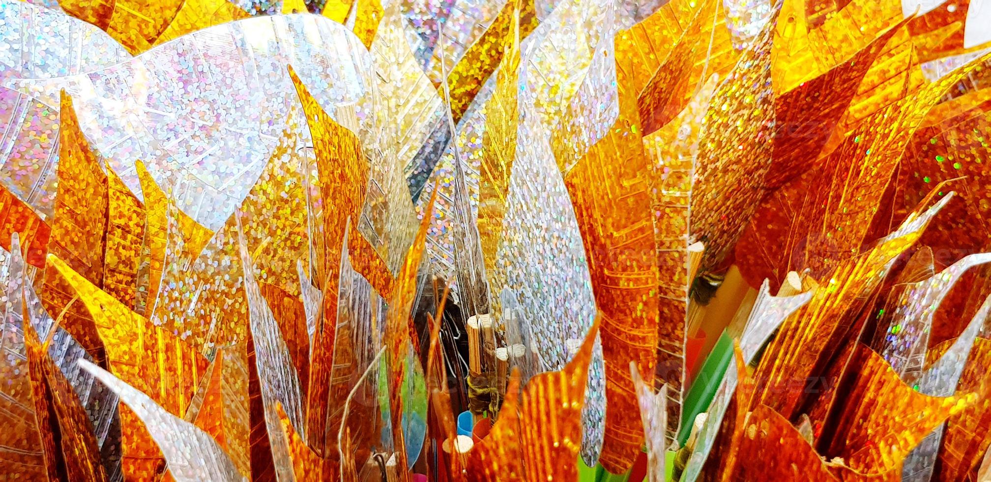 Close up silver and golden leaves for background at Thai temple. Group of object for respect holy, monk statue. Pattern of colorful leaf wallpaper photo