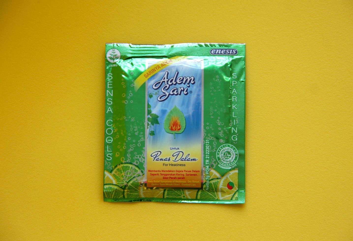 West Jakarta, Indonesia - February 10th, 2023 - Indonesian powder drink for relieving sore throat, Adem sari saset. Calming drink with cooling sparkling sensation photo on isolated yellow background.