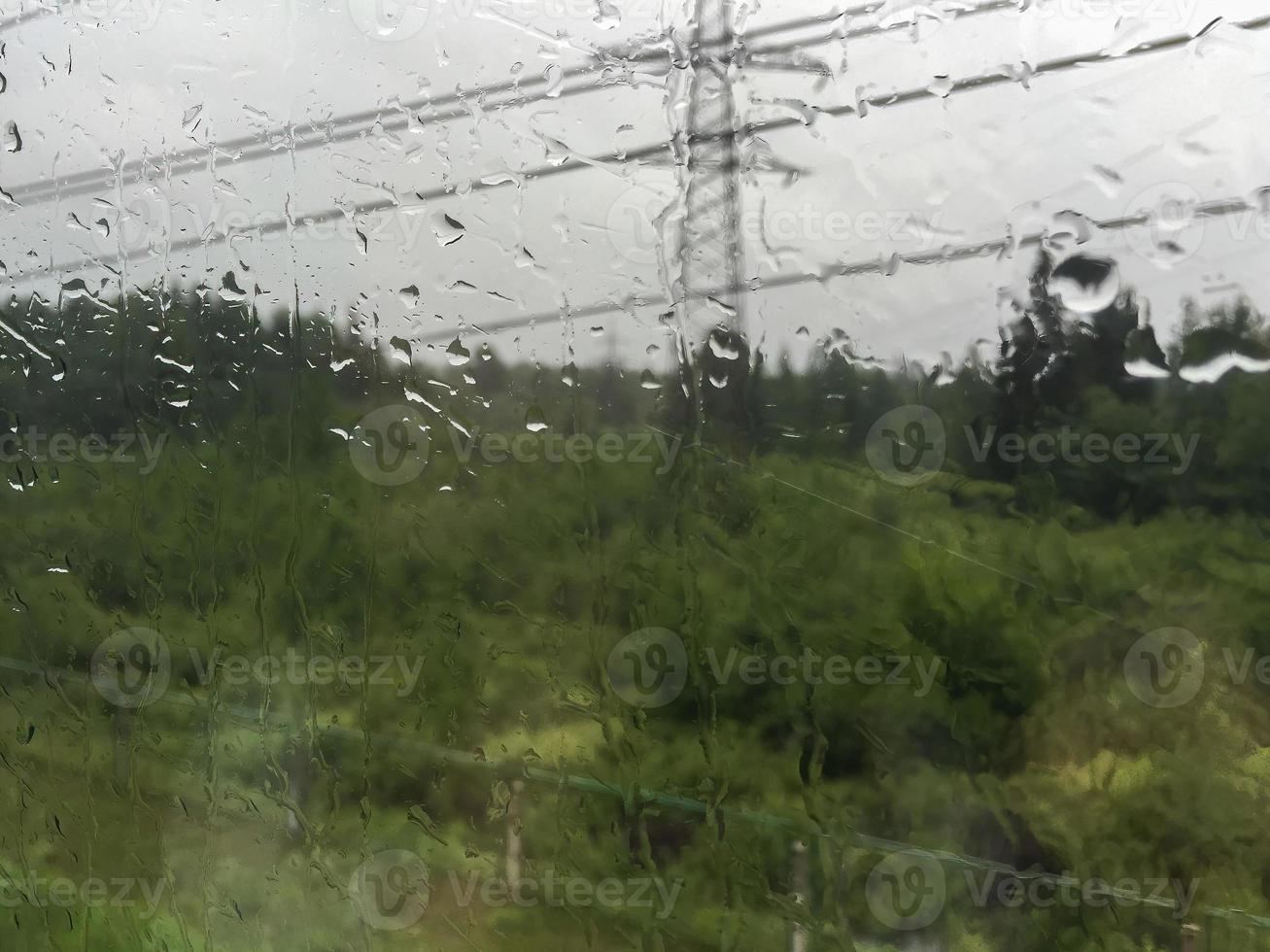 Texture of a window with raindrops. Overlooking a rural landscape. photo