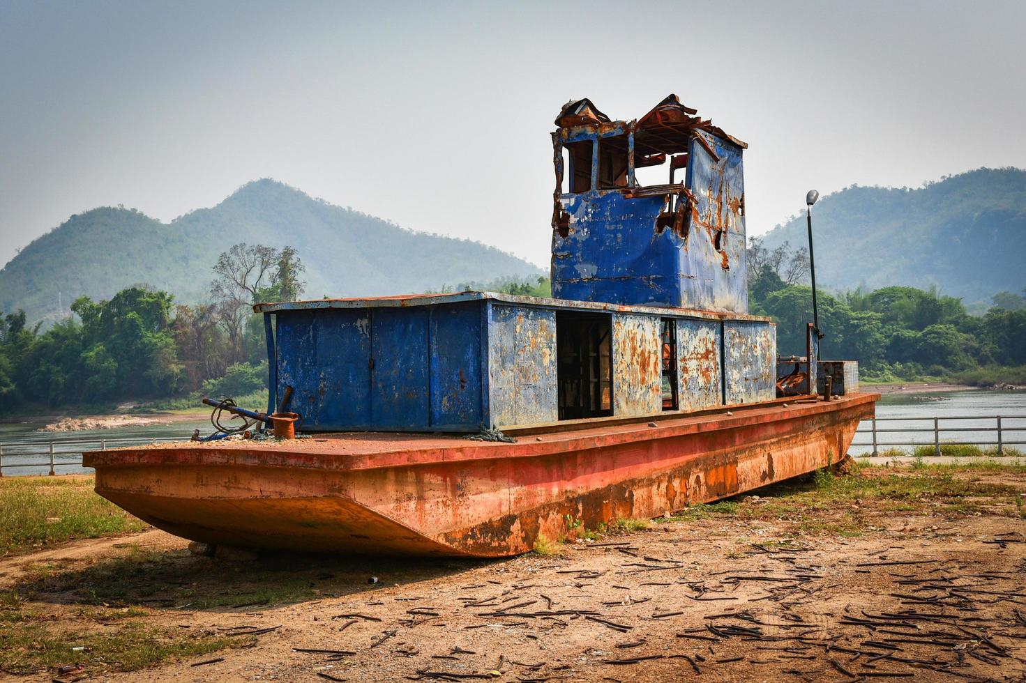 old boat on the riverside ancient ship decay steel with rust metal iron photo