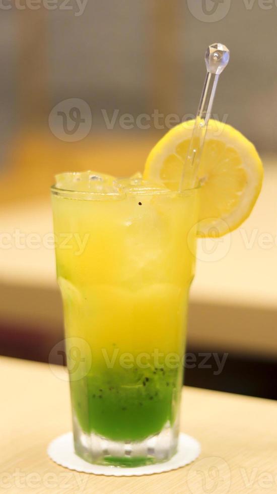 Sunrise blend juice, mix juice of kiwi, matcha, mango, apple, and orange juice, yellow and green colour juice. photo