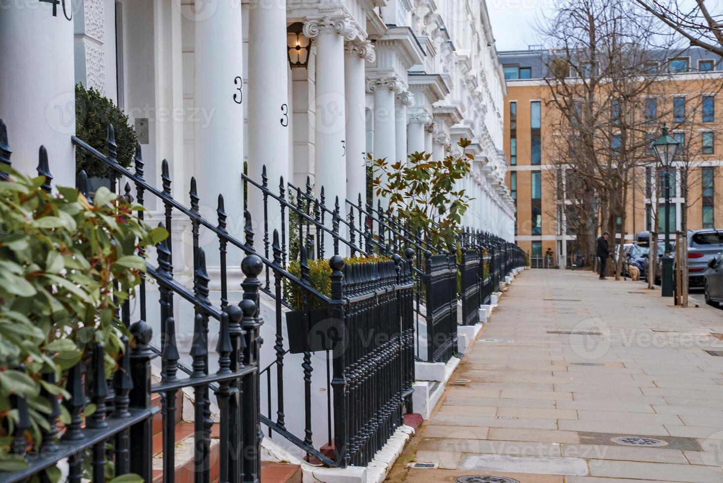 Empty sidewalk and row of beautiful white Edwardian houses in Kensington photo