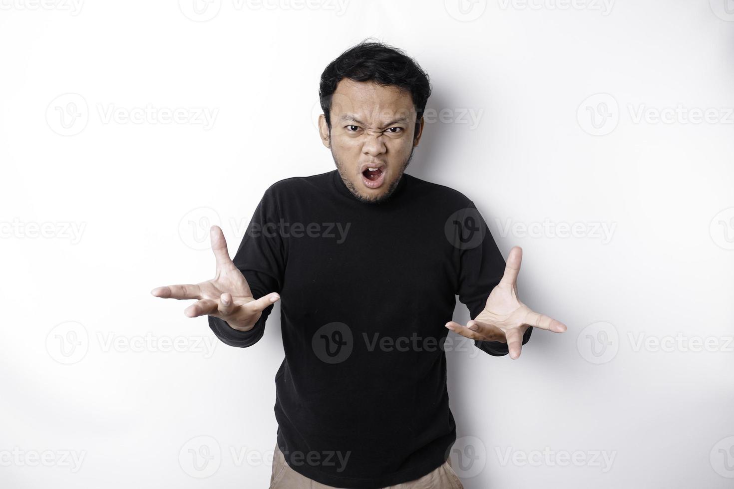 The angry and mad face of Asian man in black shirt isolated white background. photo