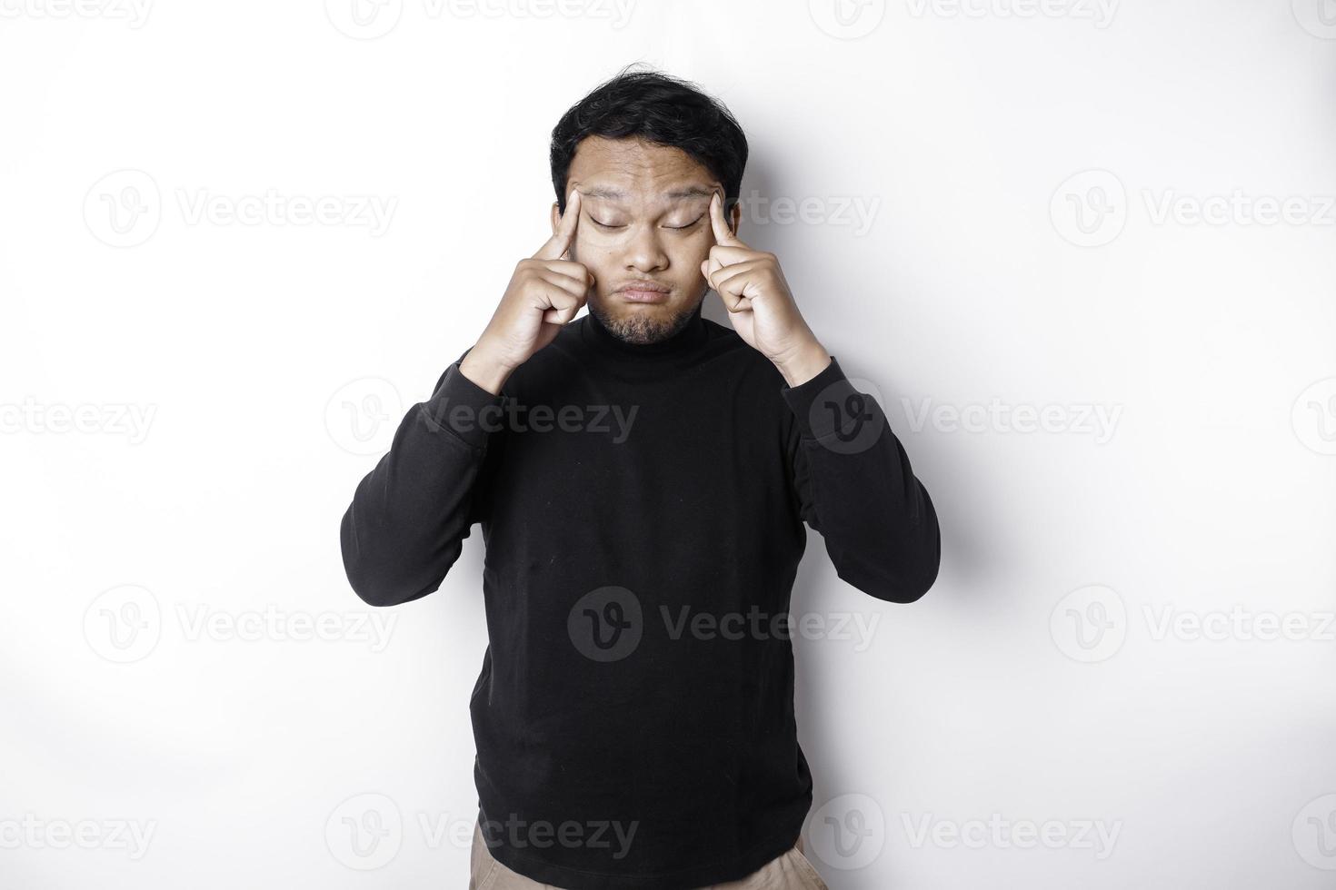 A portrait of an Asian man wearing a black shirt isolated by white background looks depressed photo