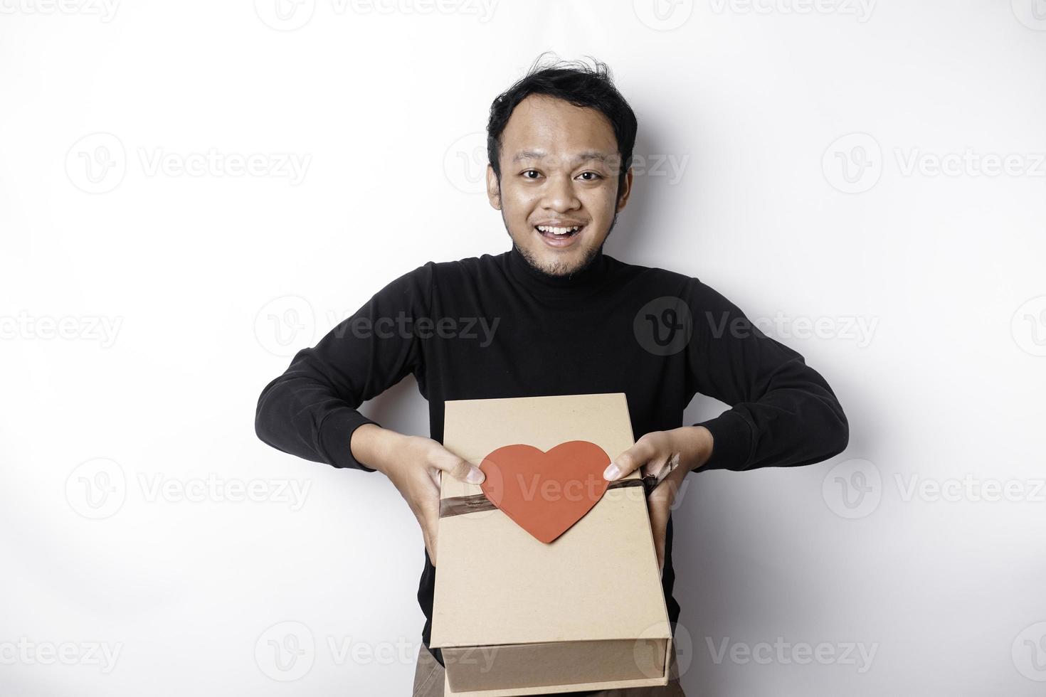 hermosa joven asiático hombre vistiendo negro camisa participación regalo caja rojo corazón, San Valentín día concepto. foto