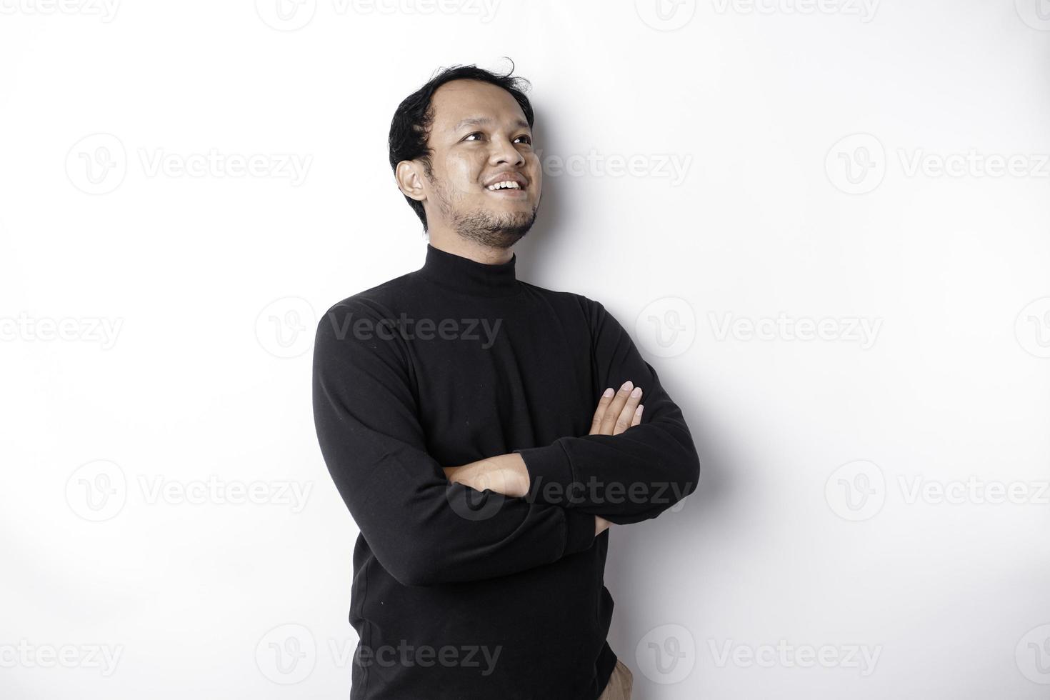 An Asian young confident man posing with crossed arm against a white background. photo