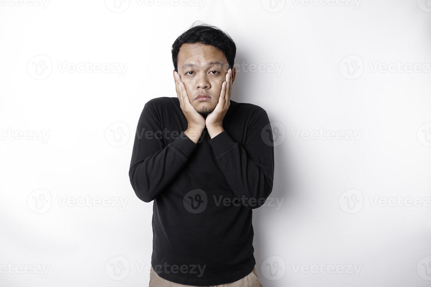 A portrait of an Asian man wearing a black shirt isolated by white background looks depressed photo