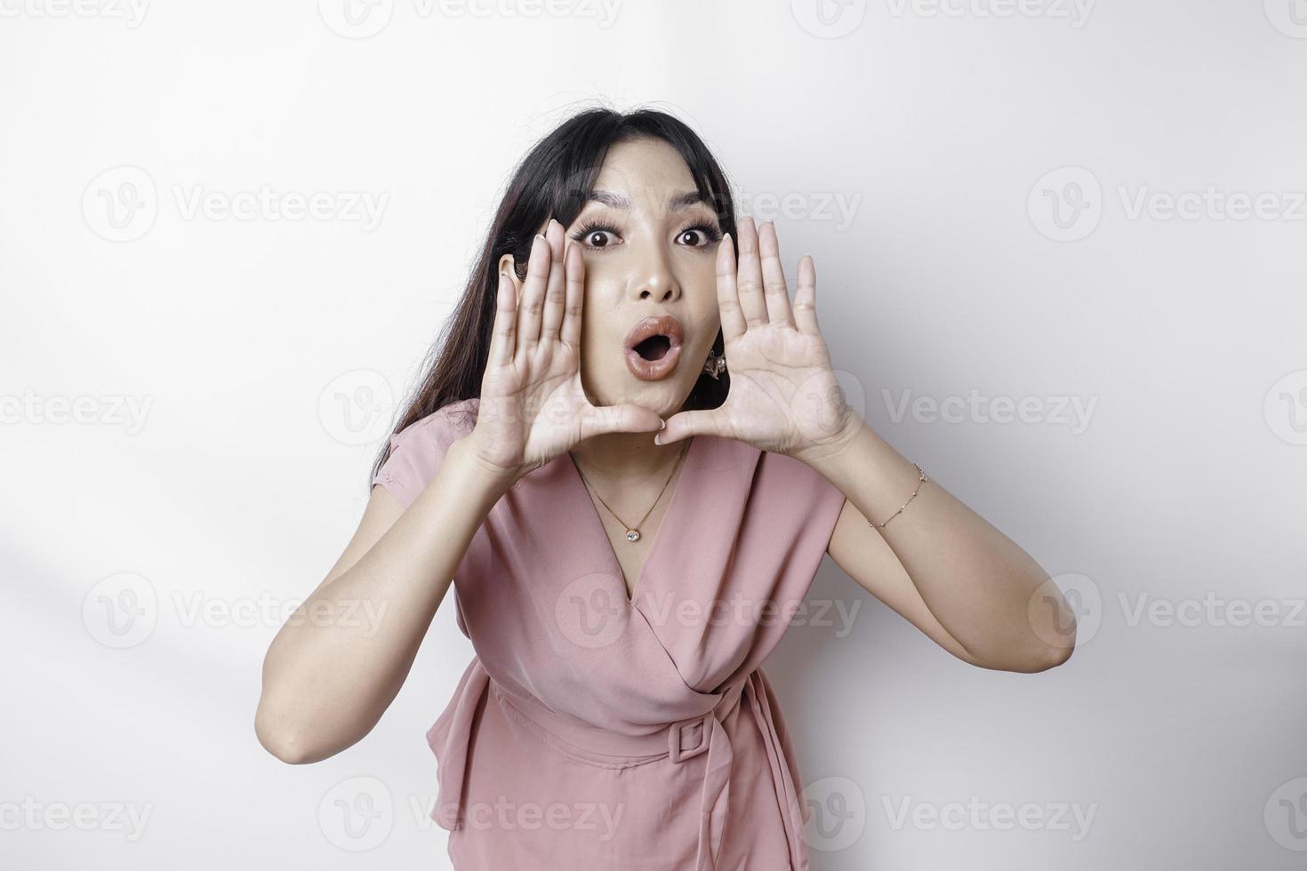 Young beautiful woman wearing a pink blouse shouting and screaming loud with a hand on her mouth. communication concept. photo