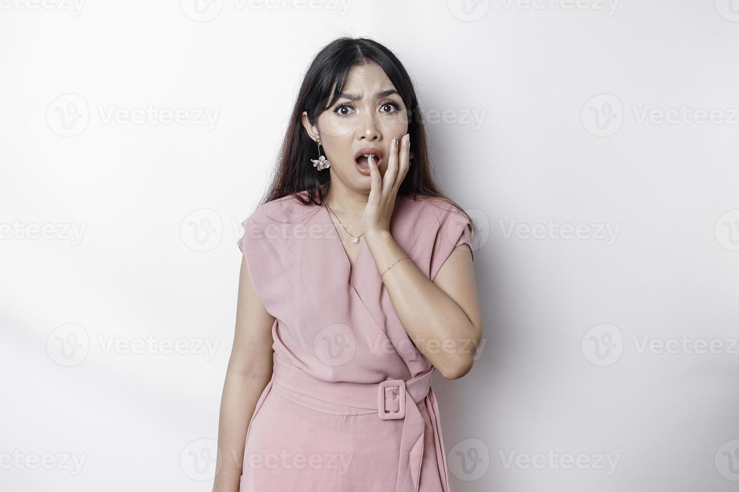 Young Asian woman isolated on white background, looks depressed, face covered by fingers frightened and nervous. photo