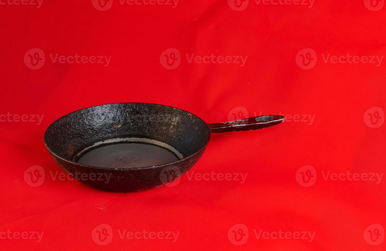 An old cast iron skillet made in circa 1960 against a red background. photo