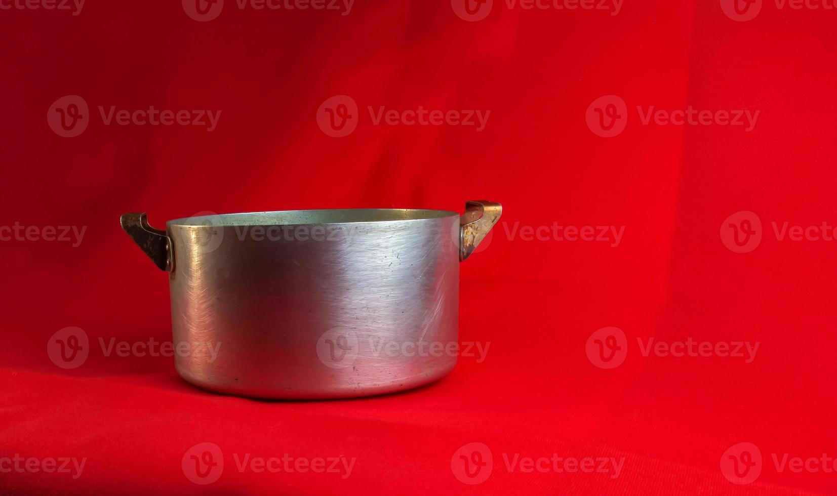 An old aluminum pan made in circa 1960 against a red background. photo