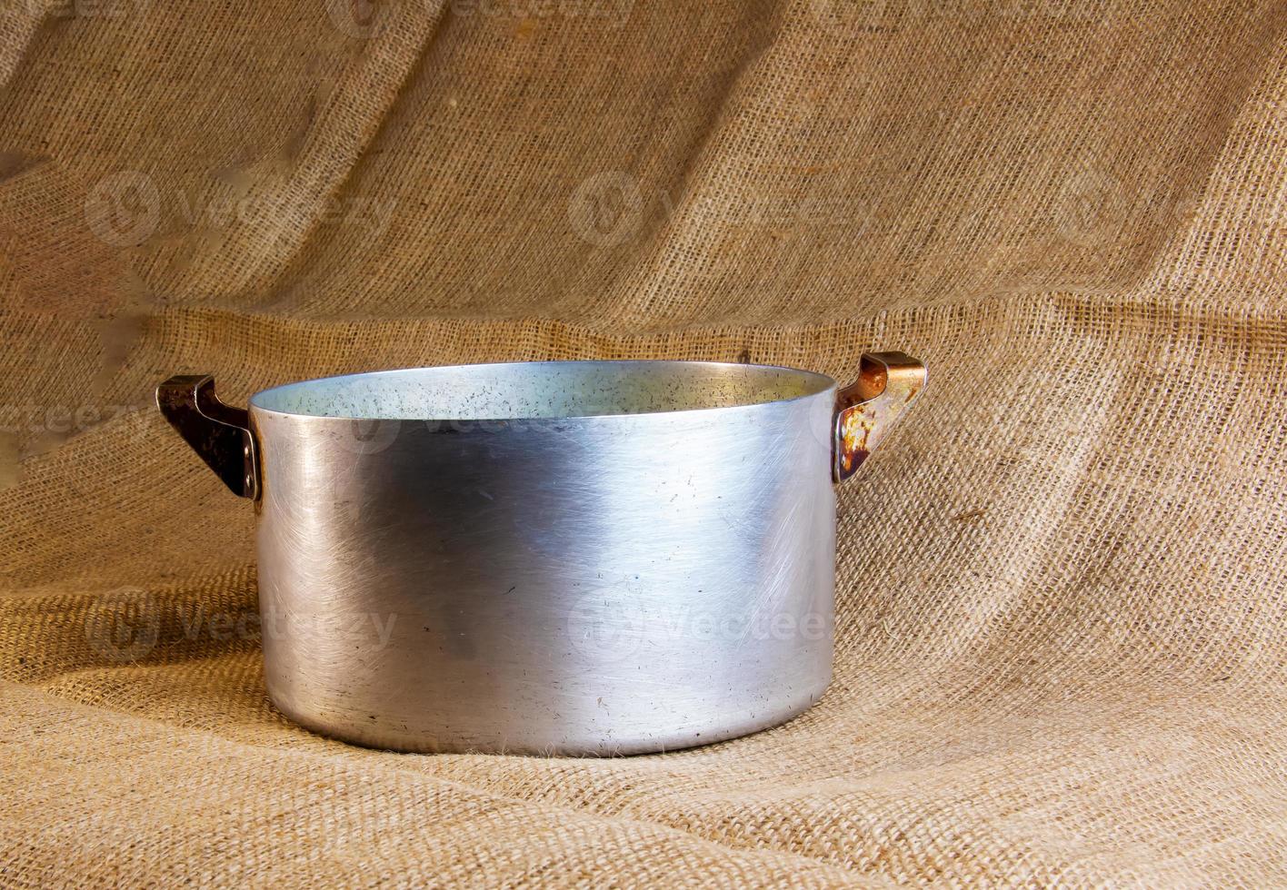 An old aluminum pan made in circa 1960 against a background of burlap. photo