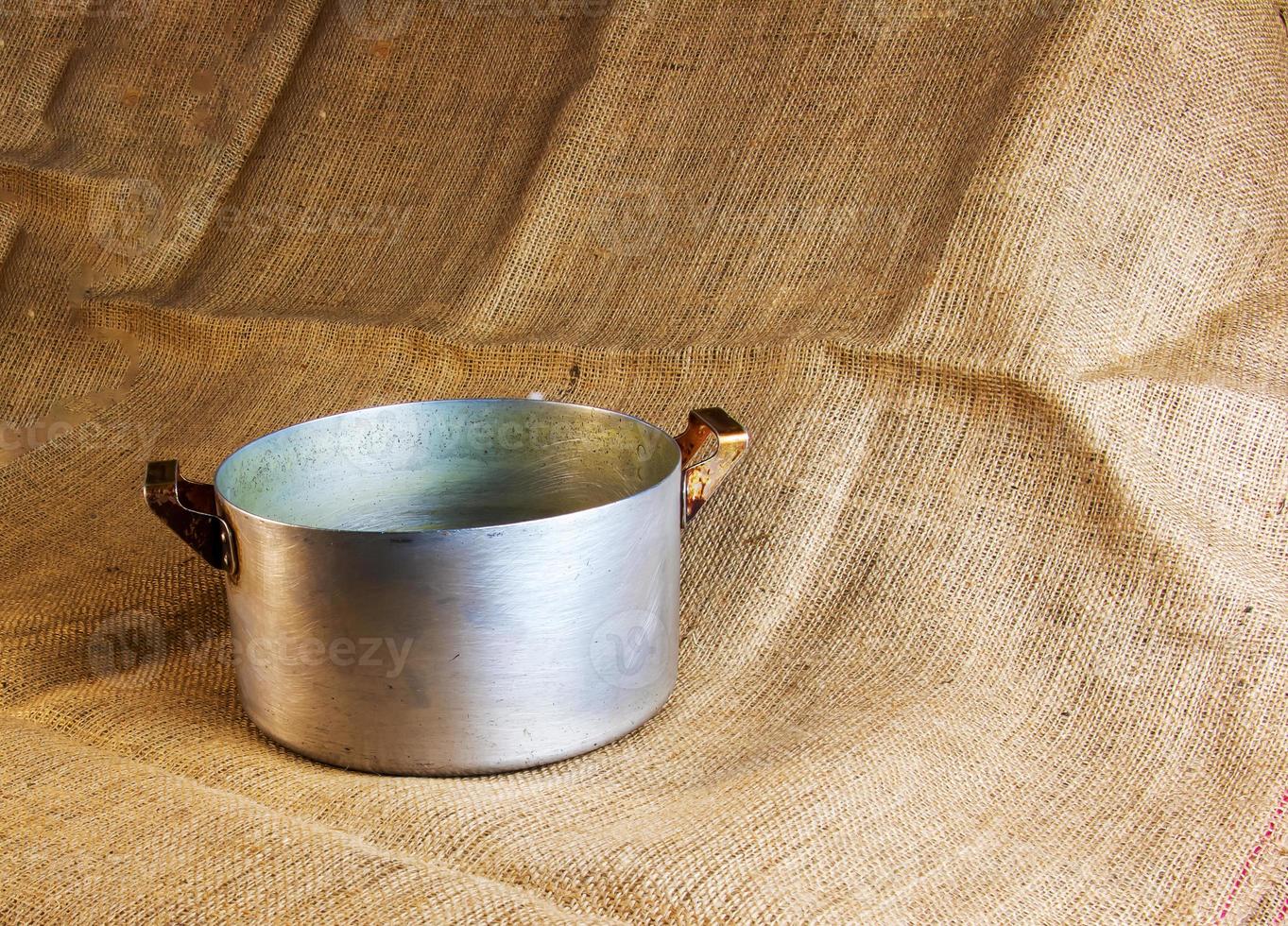 An old aluminum pan made in circa 1960 against a background of burlap. photo