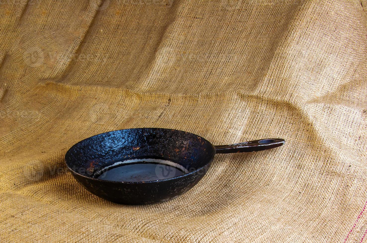 An old cast-iron skillet made in circa 1960 with burlap in the background. photo