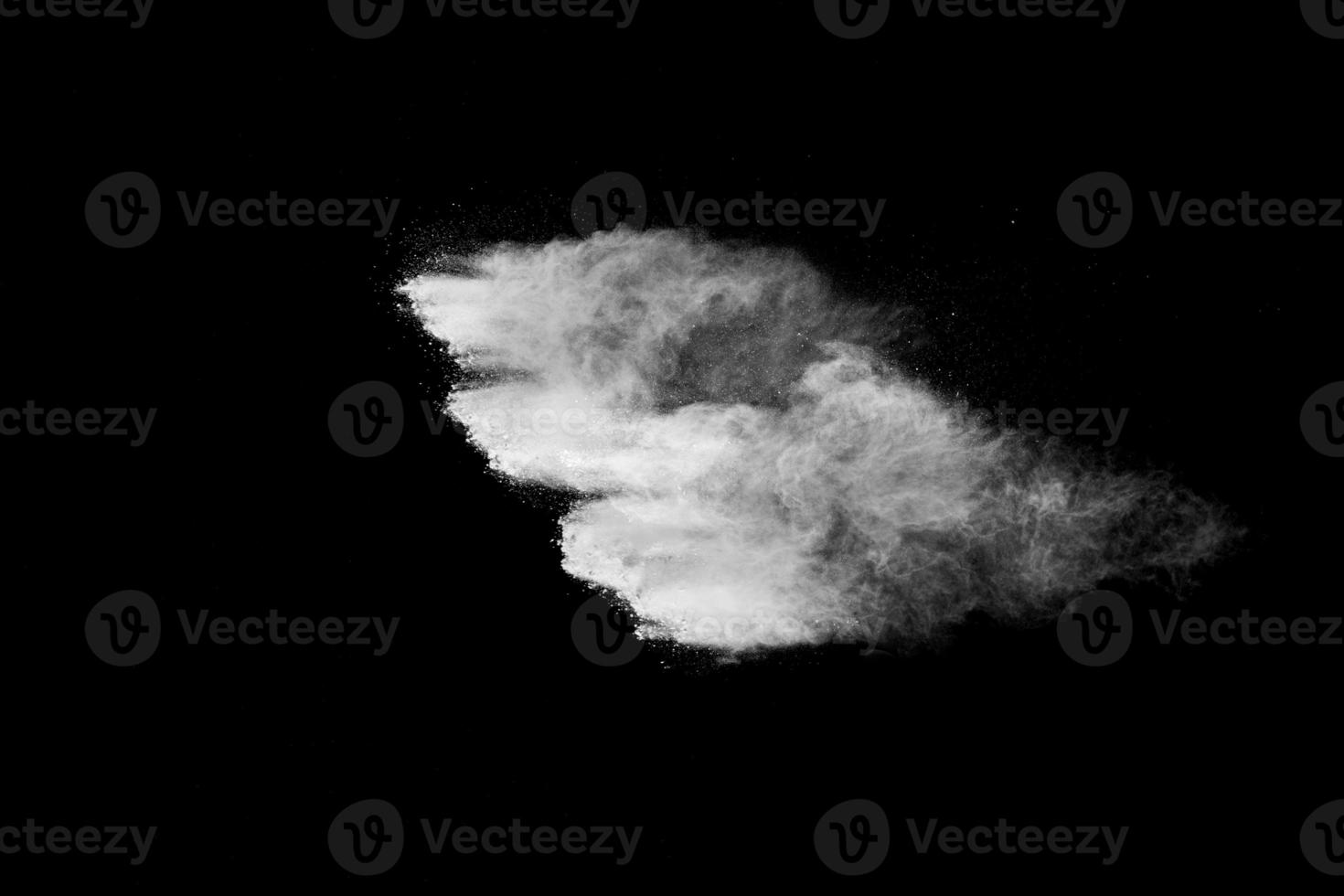 nube de explosión de polvo blanco sobre fondo negro. salpicaduras de partículas de polvo blanco. foto