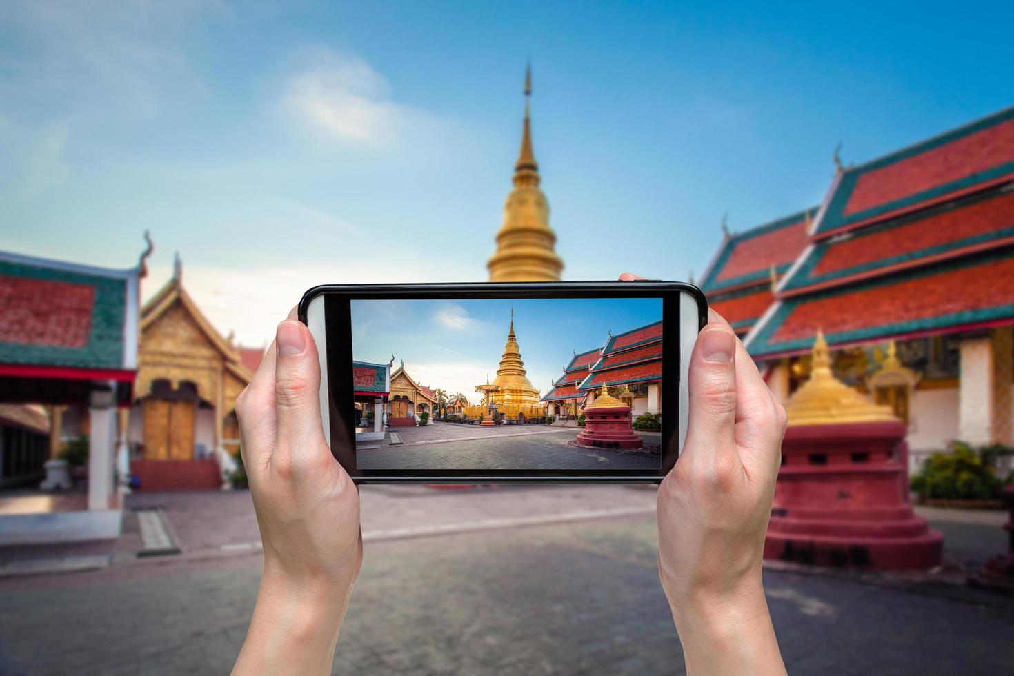 mano mujer tomando foto a wat Fratad haripunchai en lamphun, tailandia