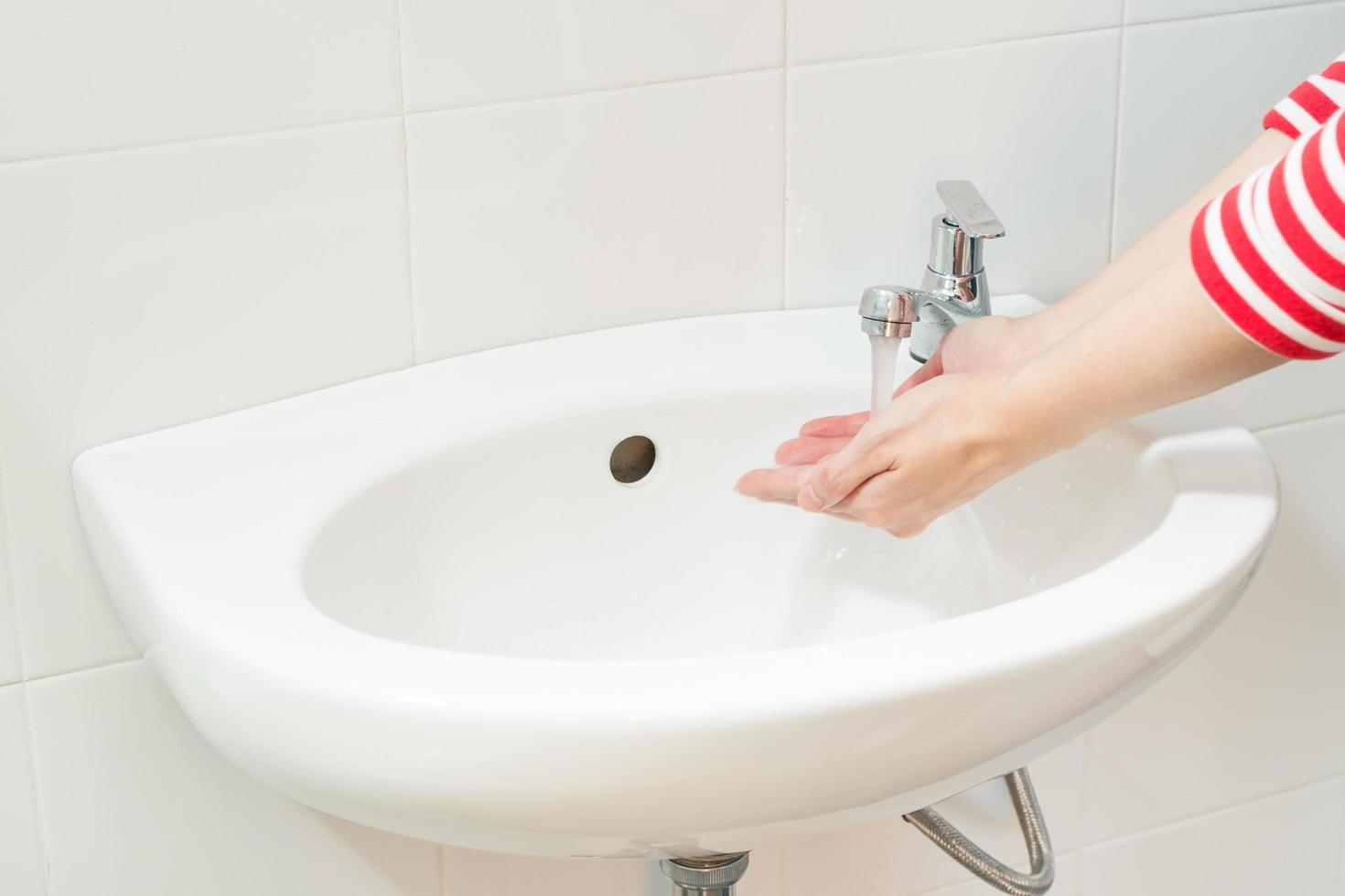Close up washing of woman hands in bathroom close up photo