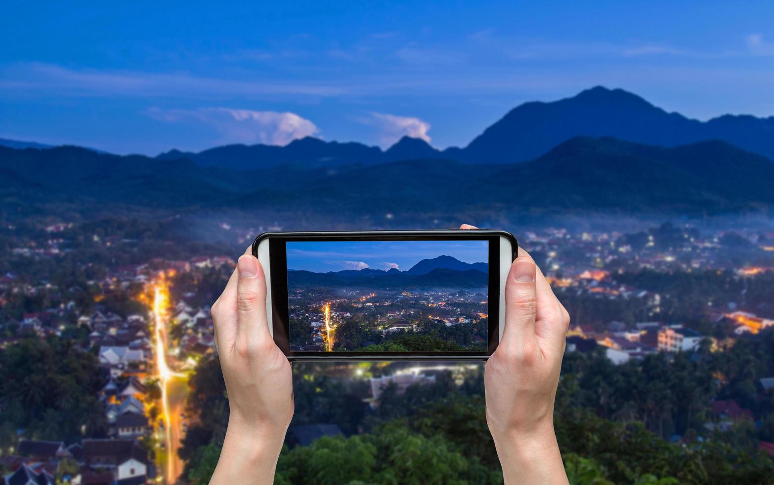 hand taking photo at viewpoint and landscape in luang prabang , laos.
