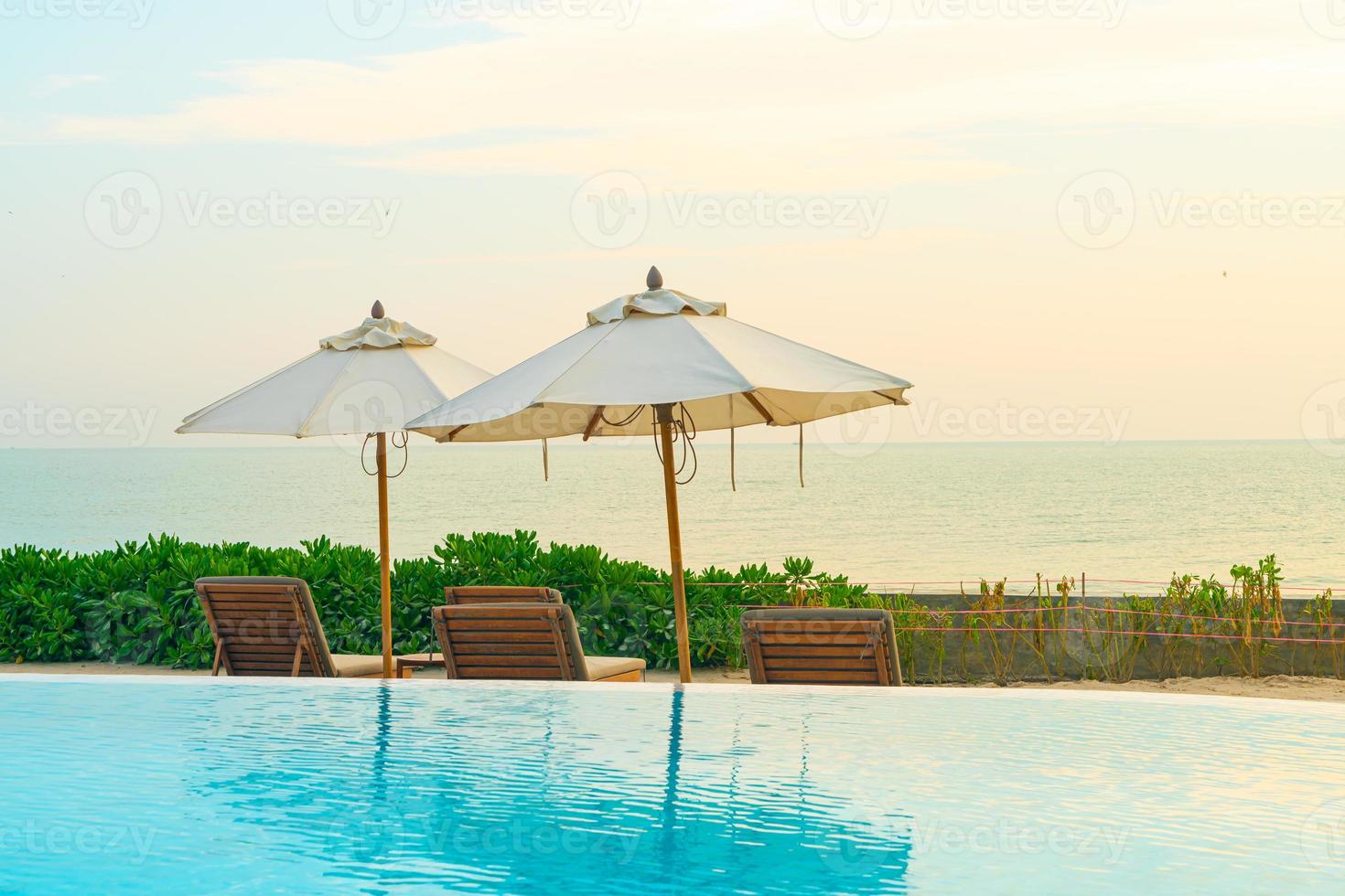 umbrella with bed pool around swimming pool with ocean sea background photo