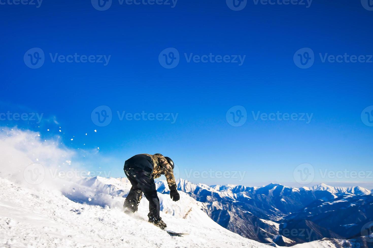 Dynamic picture snowboarder on the piste in caucasus mountains at fast speed go downhill photo