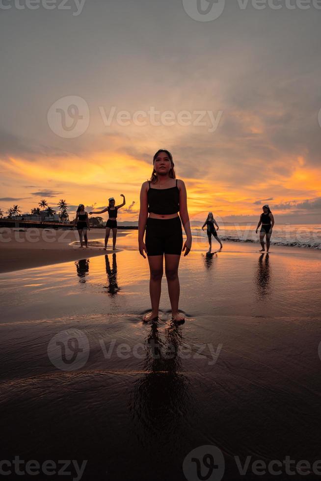 portrait of an Asian woman in black clothes standing on the beach with a very sad expression photo