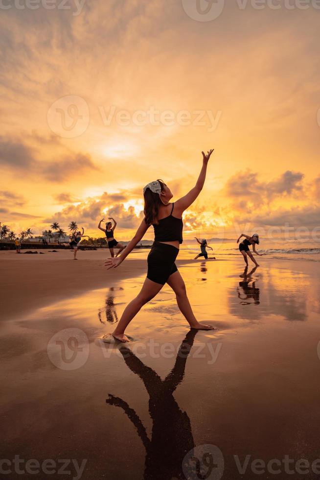 a group of Asian women dancing together and full of joy on the beach photo