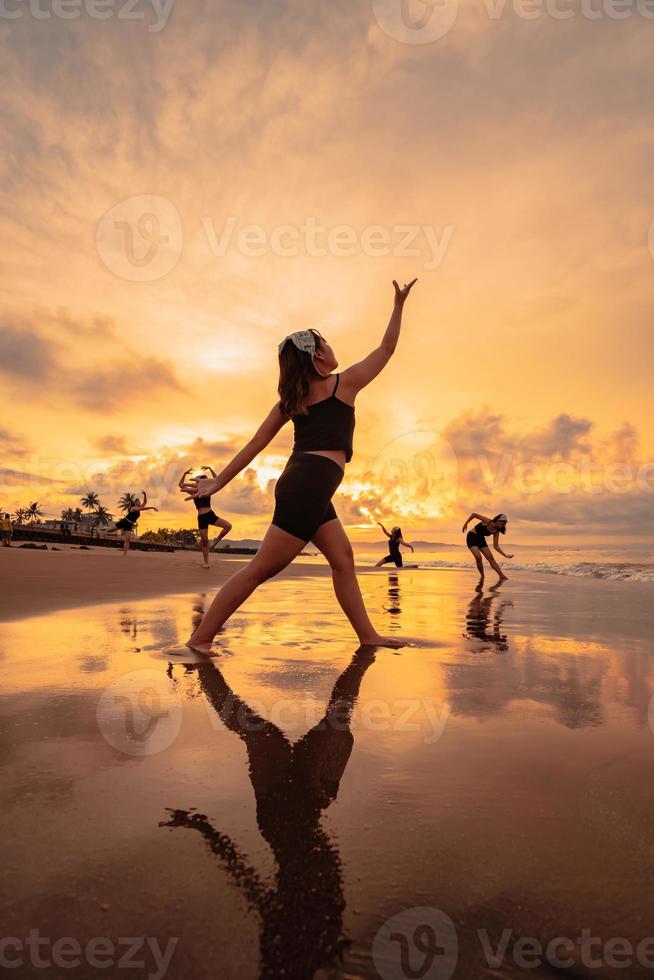 a group of Asian women dancing together and full of joy on the beach photo