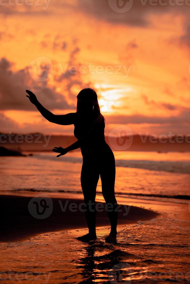 an Asian teenager dancing ballet in black for a festival by the beach photo