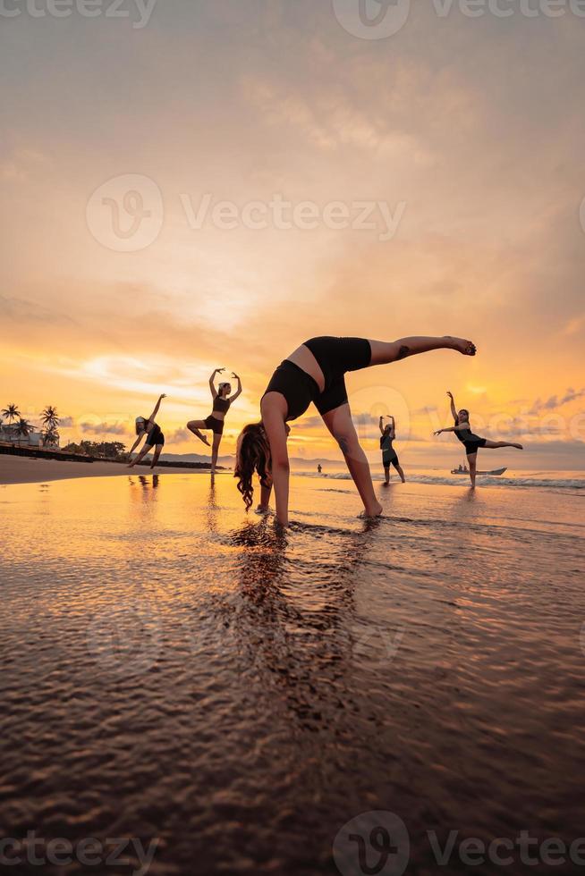 a group of Indonesian women doing gymnastic exercises very agile on the beach photo