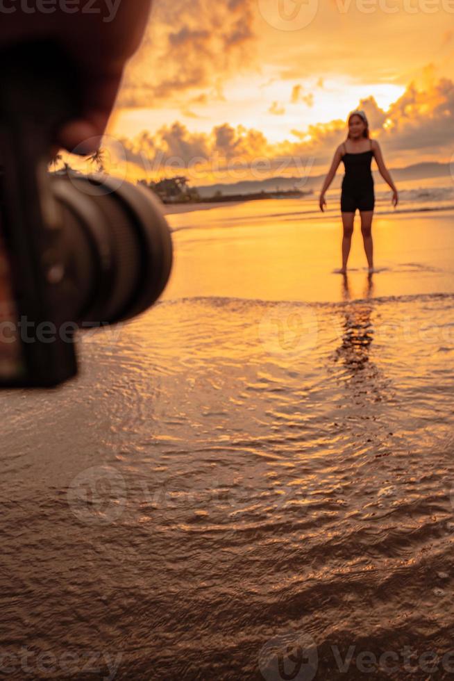 un cámara fotografias un asiático mujer haciendo un ballet danza solitario en el playa foto