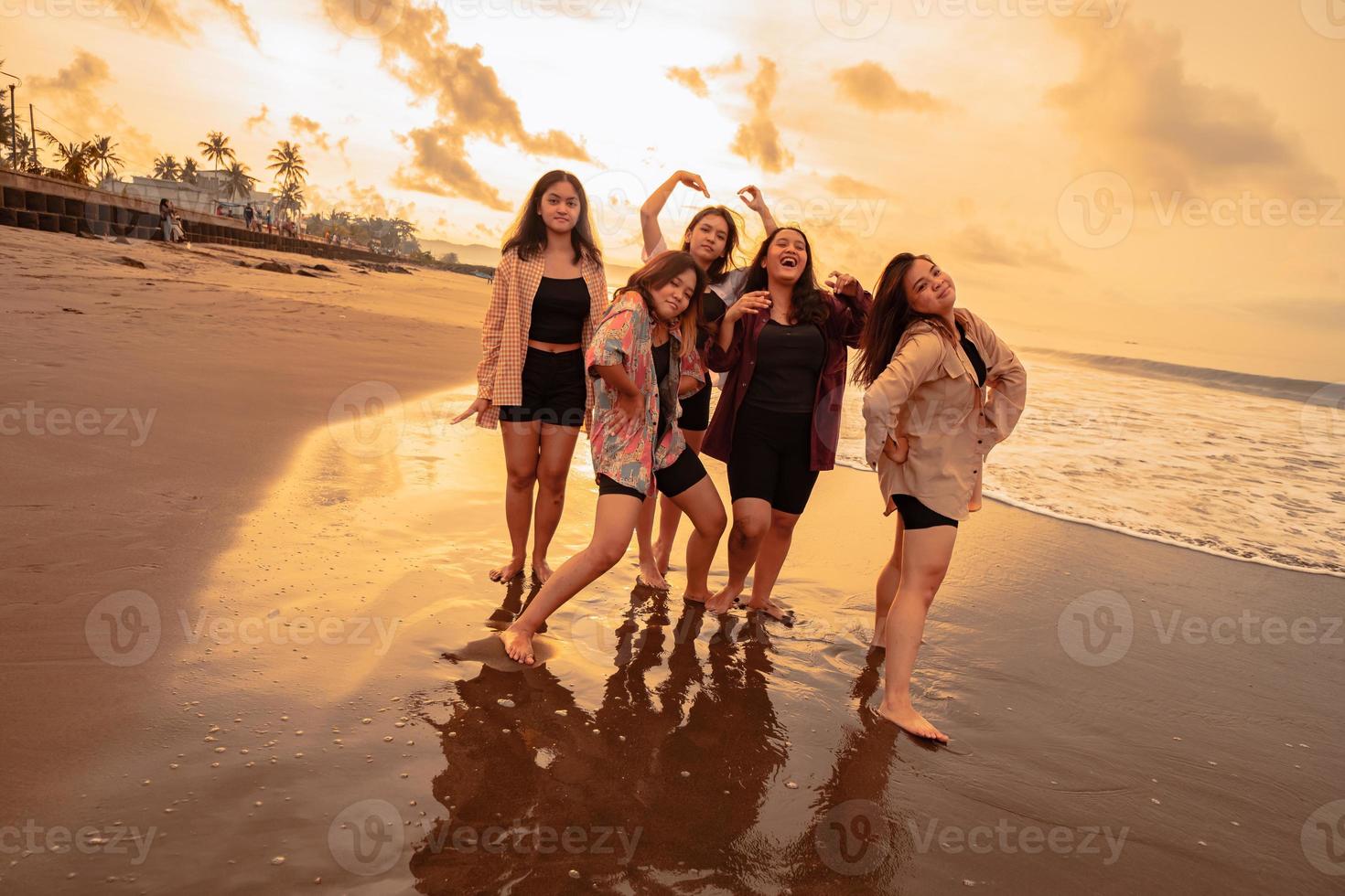 un grupo de asiático mujer disfrutando su fiesta muy loco con su amigos y con un lleno expresión de tontería en el playa foto