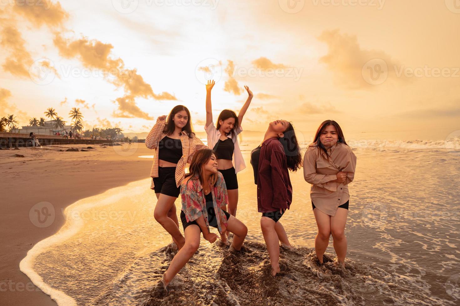 un grupo de asiático mujer disfrutando su fiesta muy loco con su amigos y con un lleno expresión de tontería en el playa foto