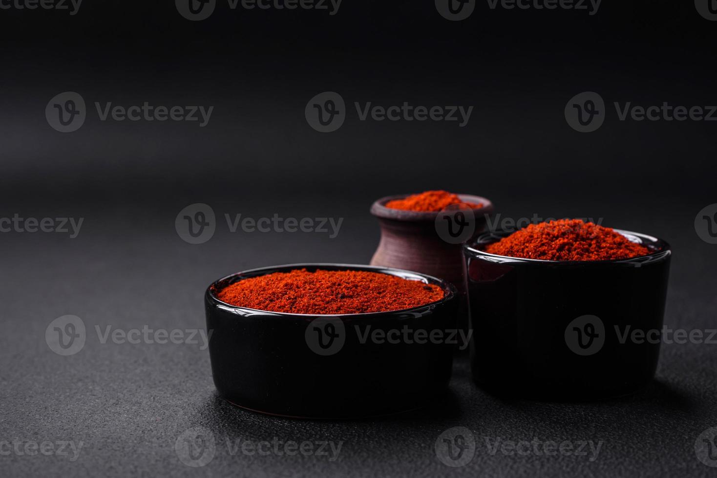 Spice smoked paprika in the form of powder in bowls and spoons photo