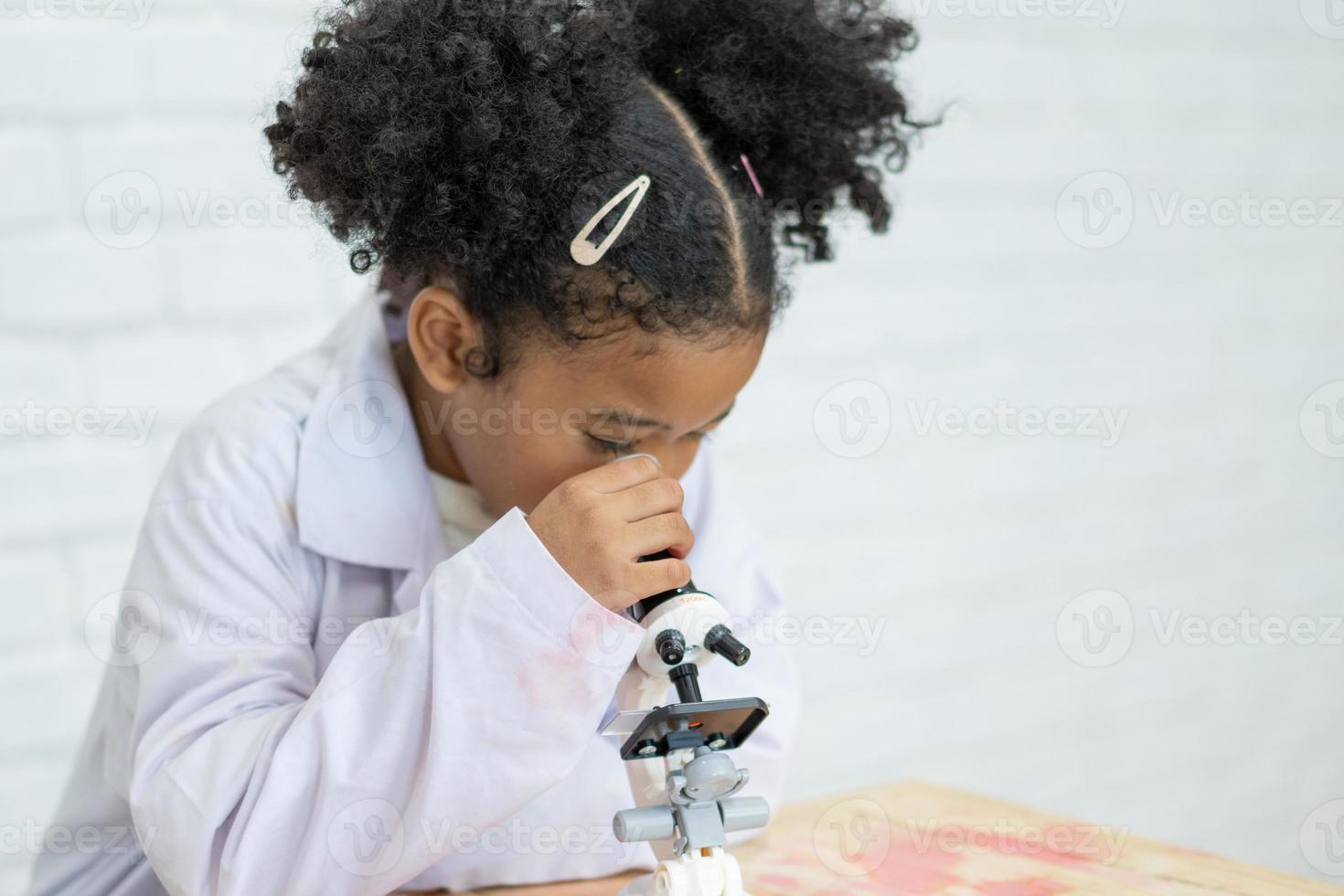 Lovely little girl scientist enjoy and excite to examine the color chemical in laboratory by using dropper with day light. Excited Kid celebrating over successful science experiment result or chemical photo