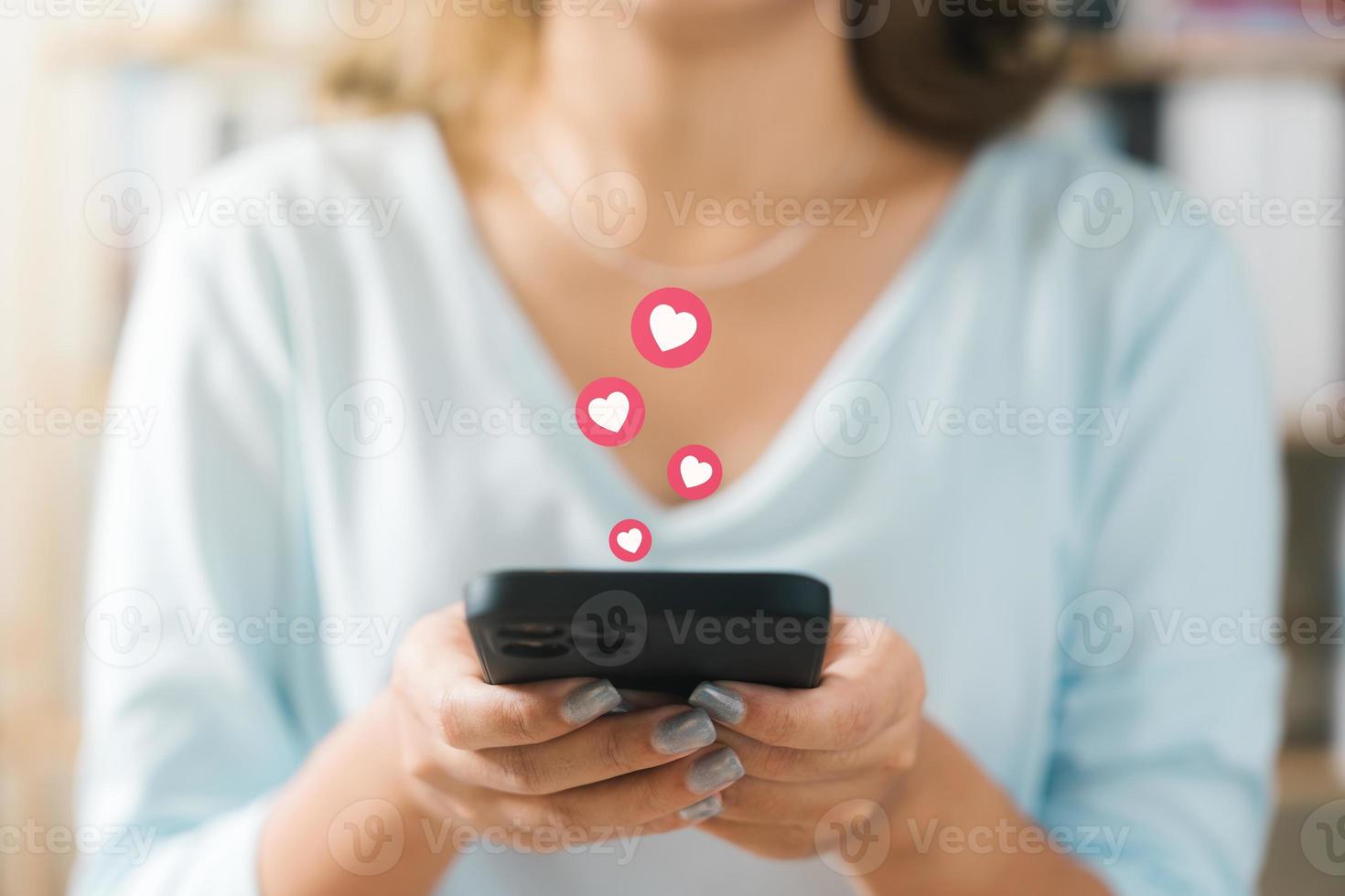 San Valentín día y amor día concepto, mujer dedo conmovedor corazón icono en pantalla en teléfono inteligente solicitud, contento mujer destino amor corazón emoji icono botón, buscar aplicación en línea Pareja. foto