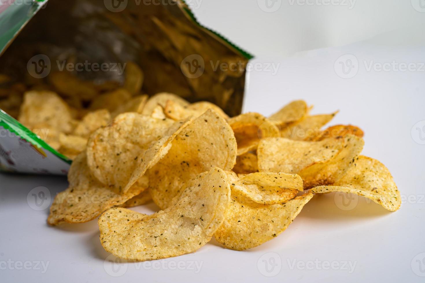 Potato chips, roasted seaweed for crips, thin slice deep fried snack fast food in open bag. photo