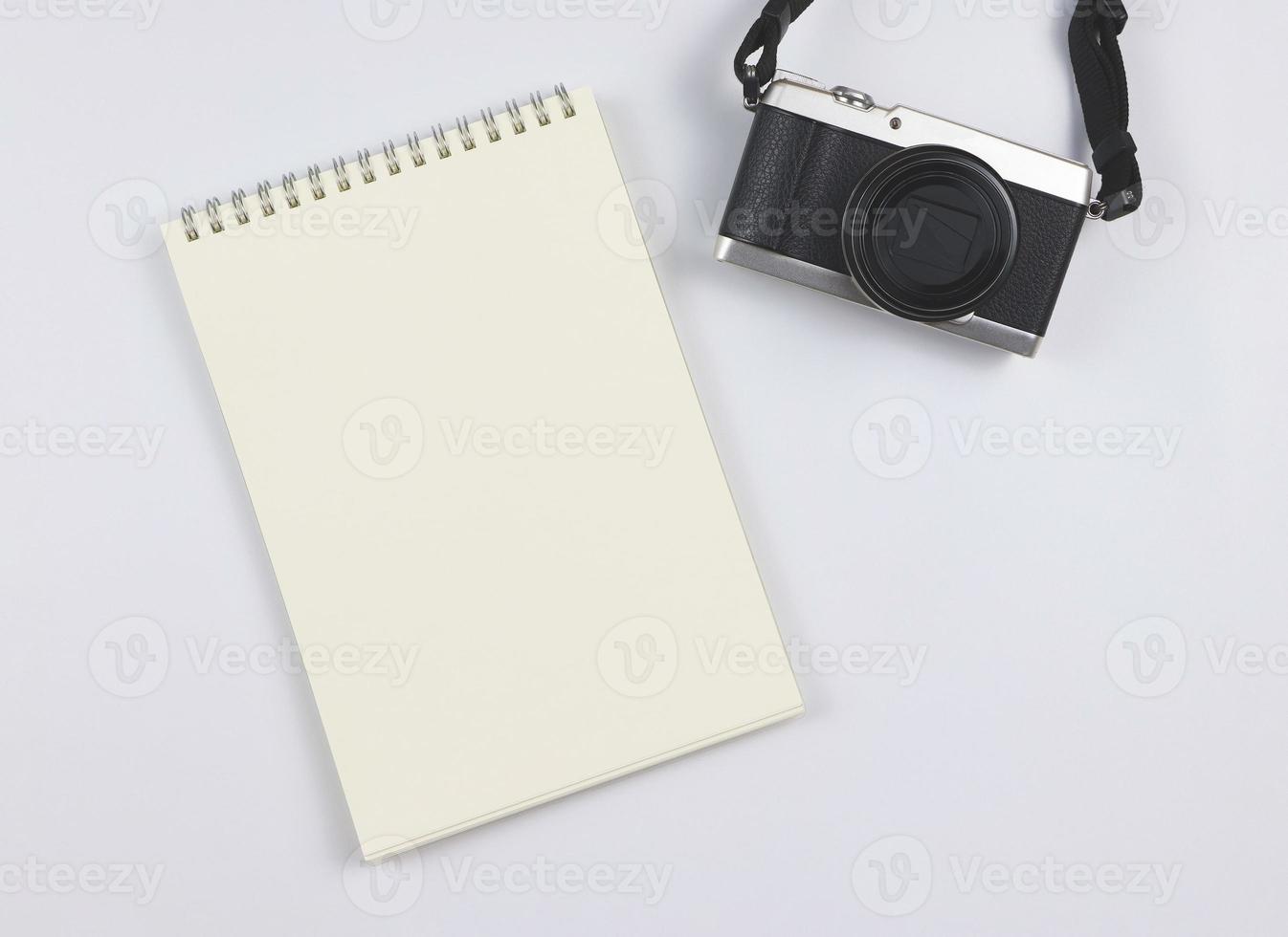 plano laico de blanco página abrió cuaderno y cámara en blanco antecedentes con Copiar espacio. foto y memoria concepto.
