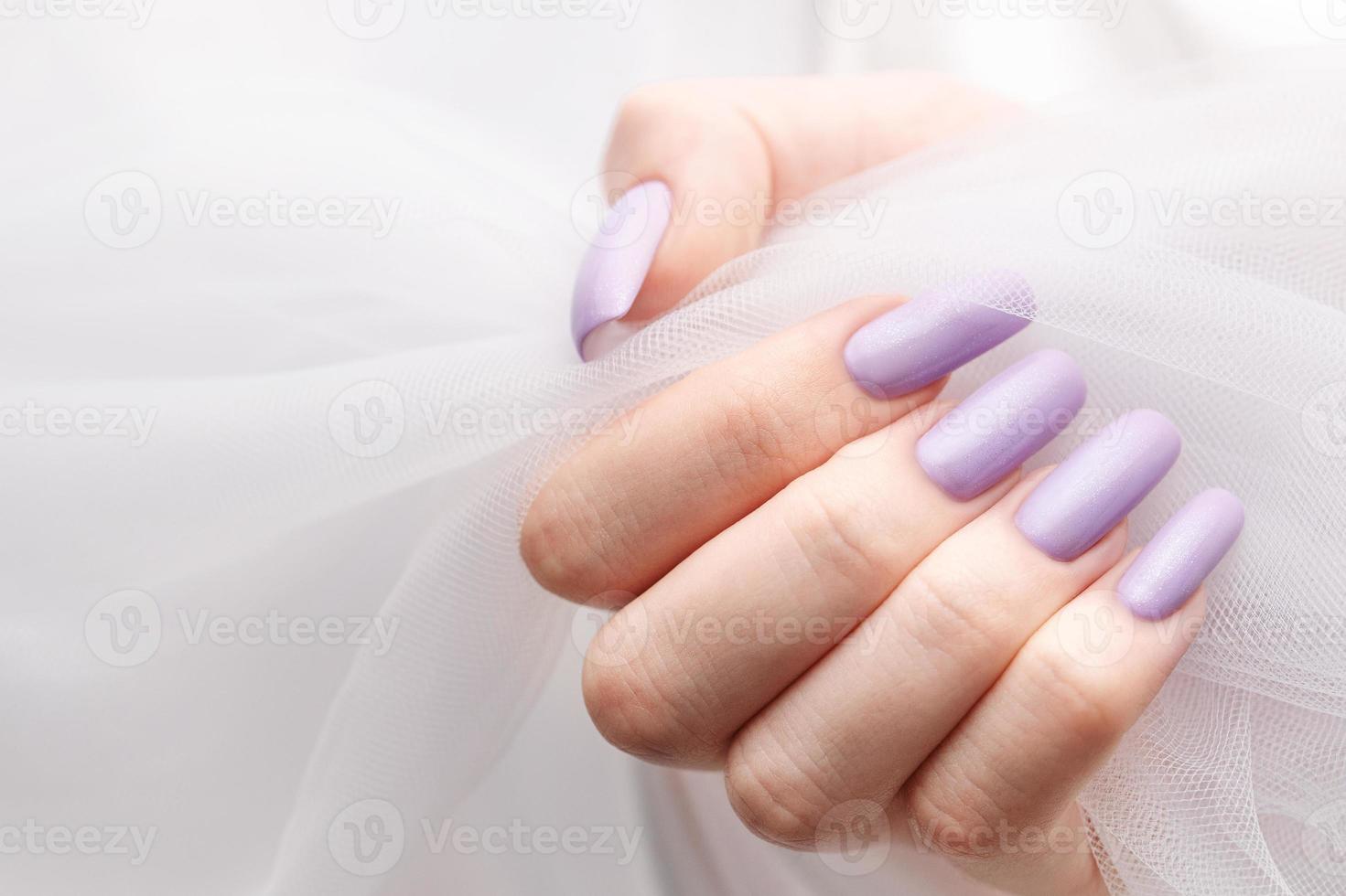 Girl's hands with a soft purple manicure. photo