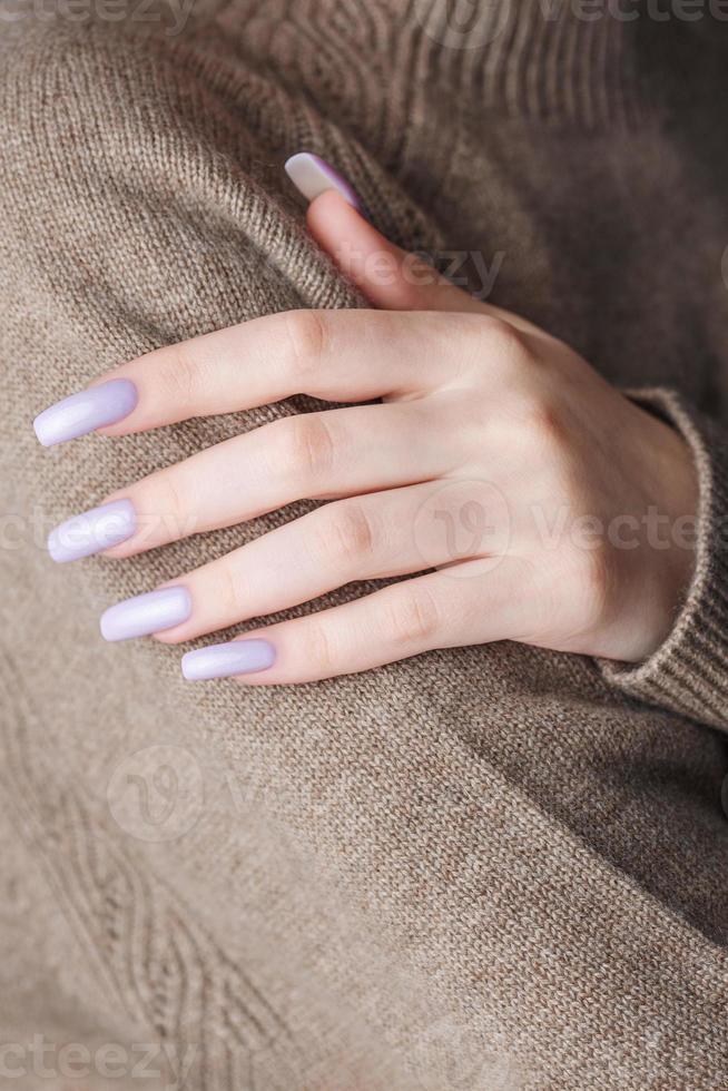 Girl's hands with a soft purple manicure. photo