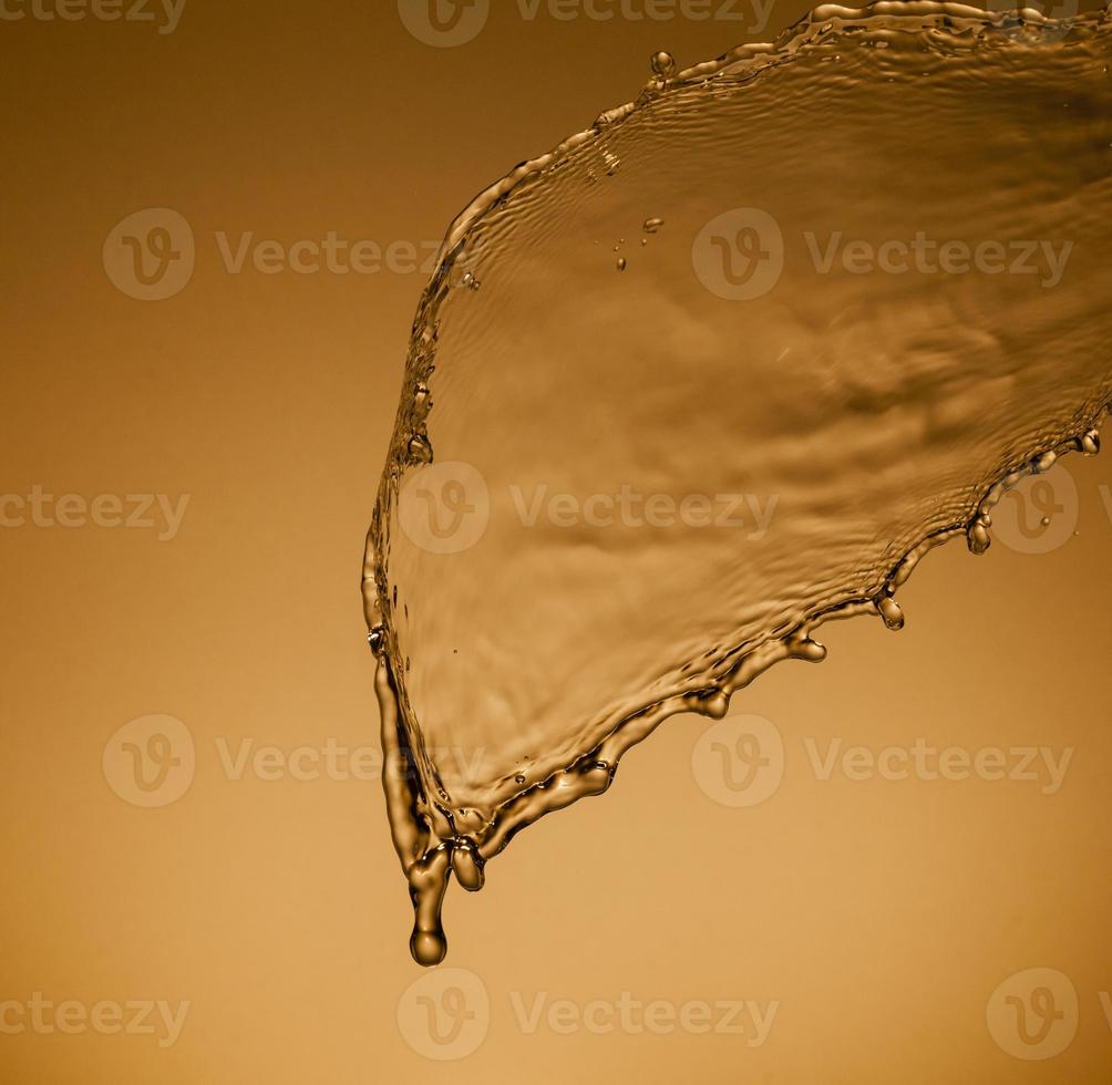 Falling water on a golden background photo