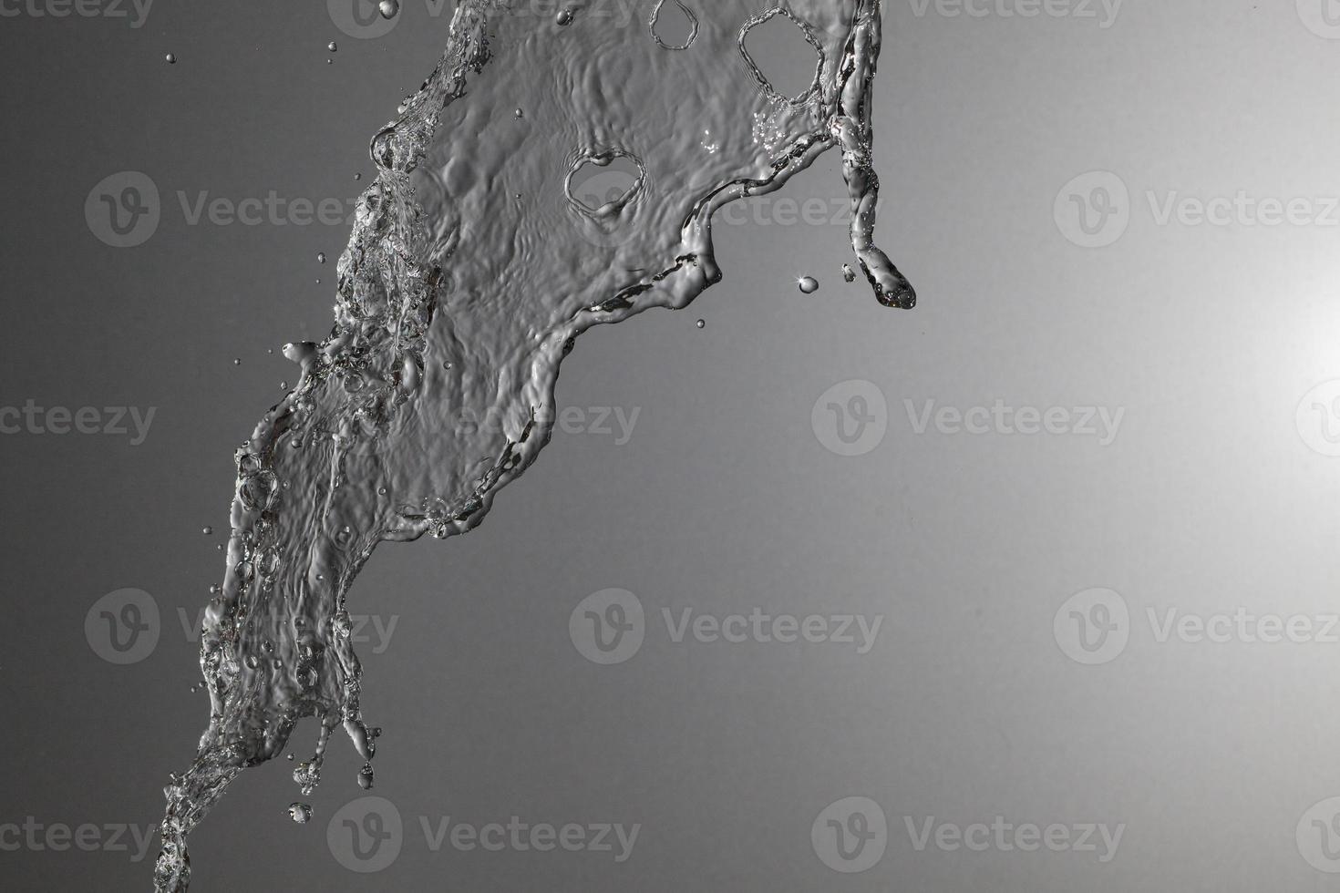 Falling water on a silver background photo