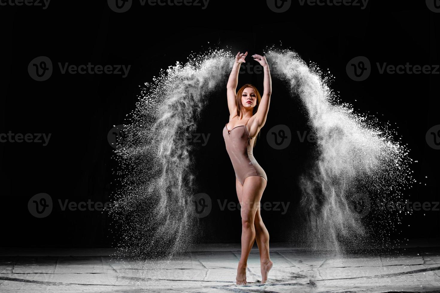 Young slim woman with spread flour on the air photo