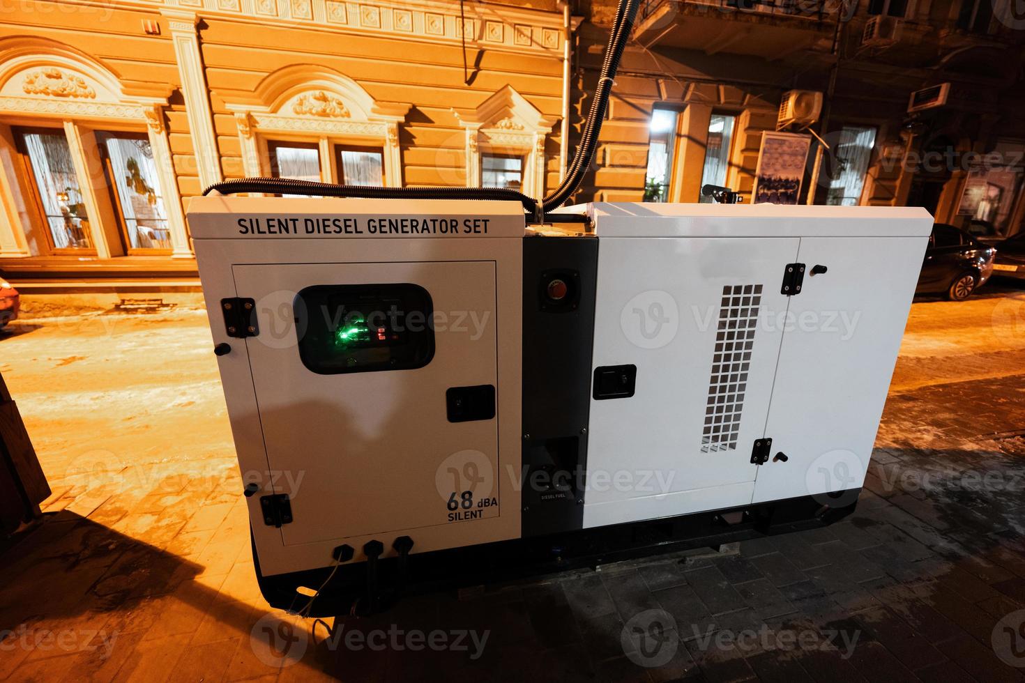Large stationary diesel power three phase electric silent generator set in evening city. photo