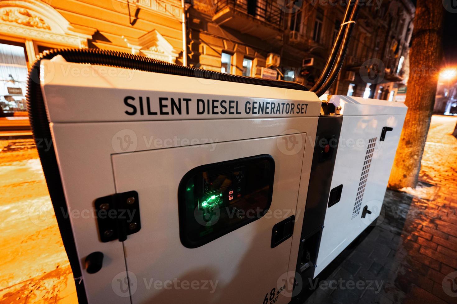 Large stationary diesel power three phase electric silent generator set in evening city. photo