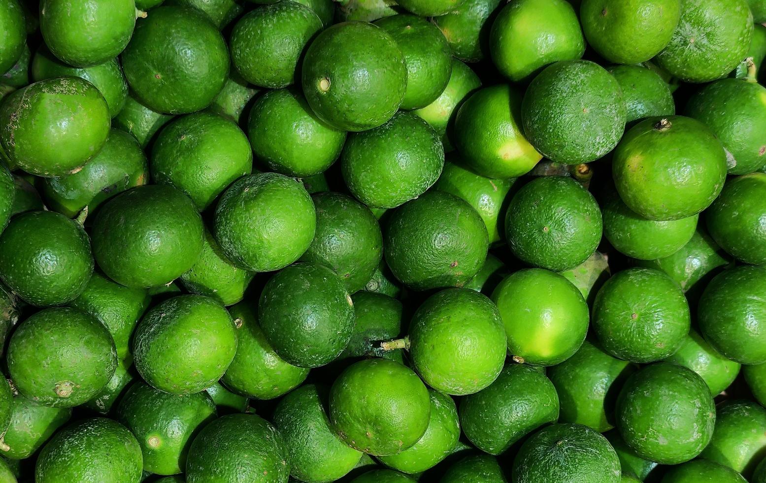 Green lime fruit pile background. Top view. photo