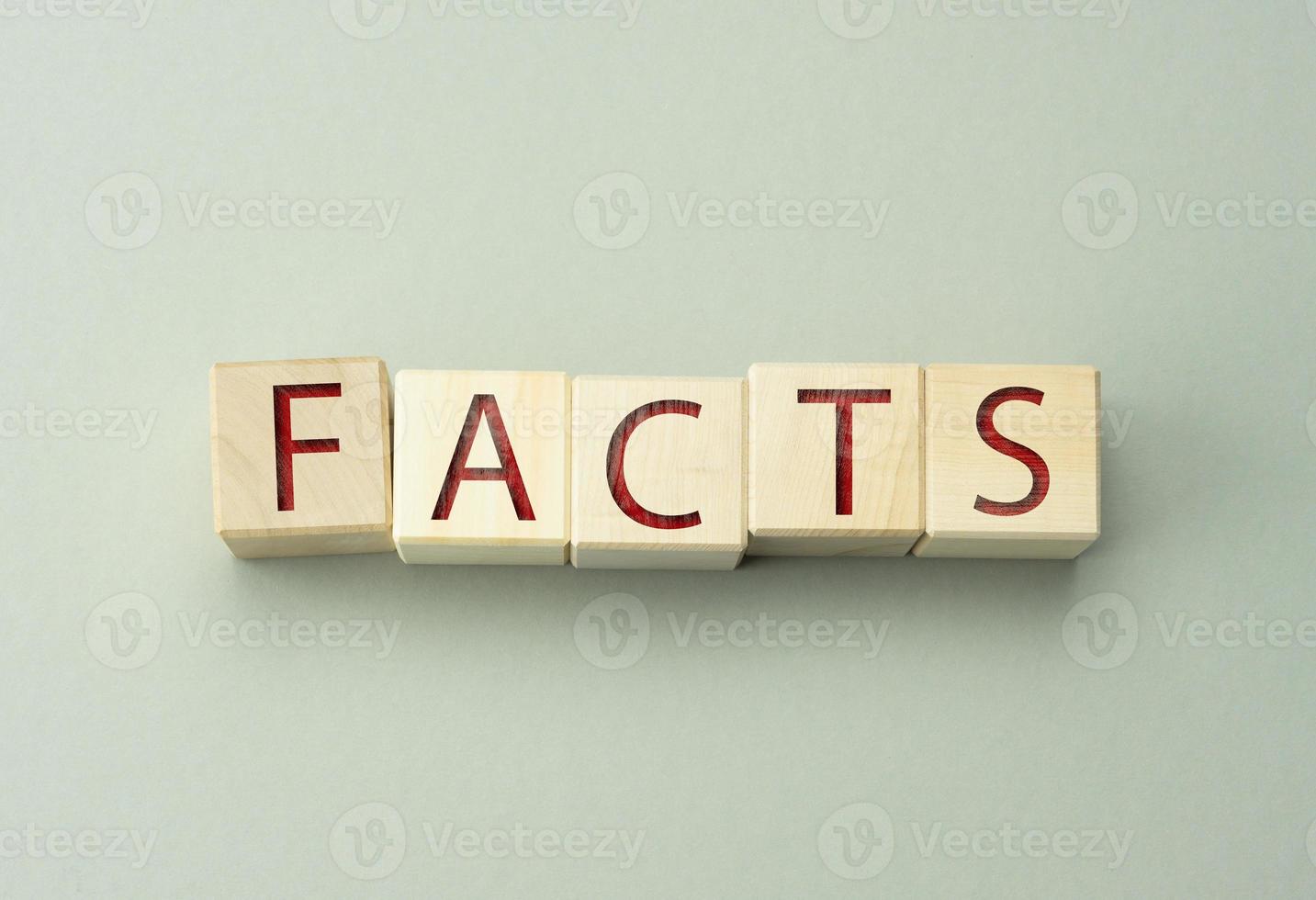 wooden cubes with the inscription facts on a gray background. Valid data concept, information verification photo