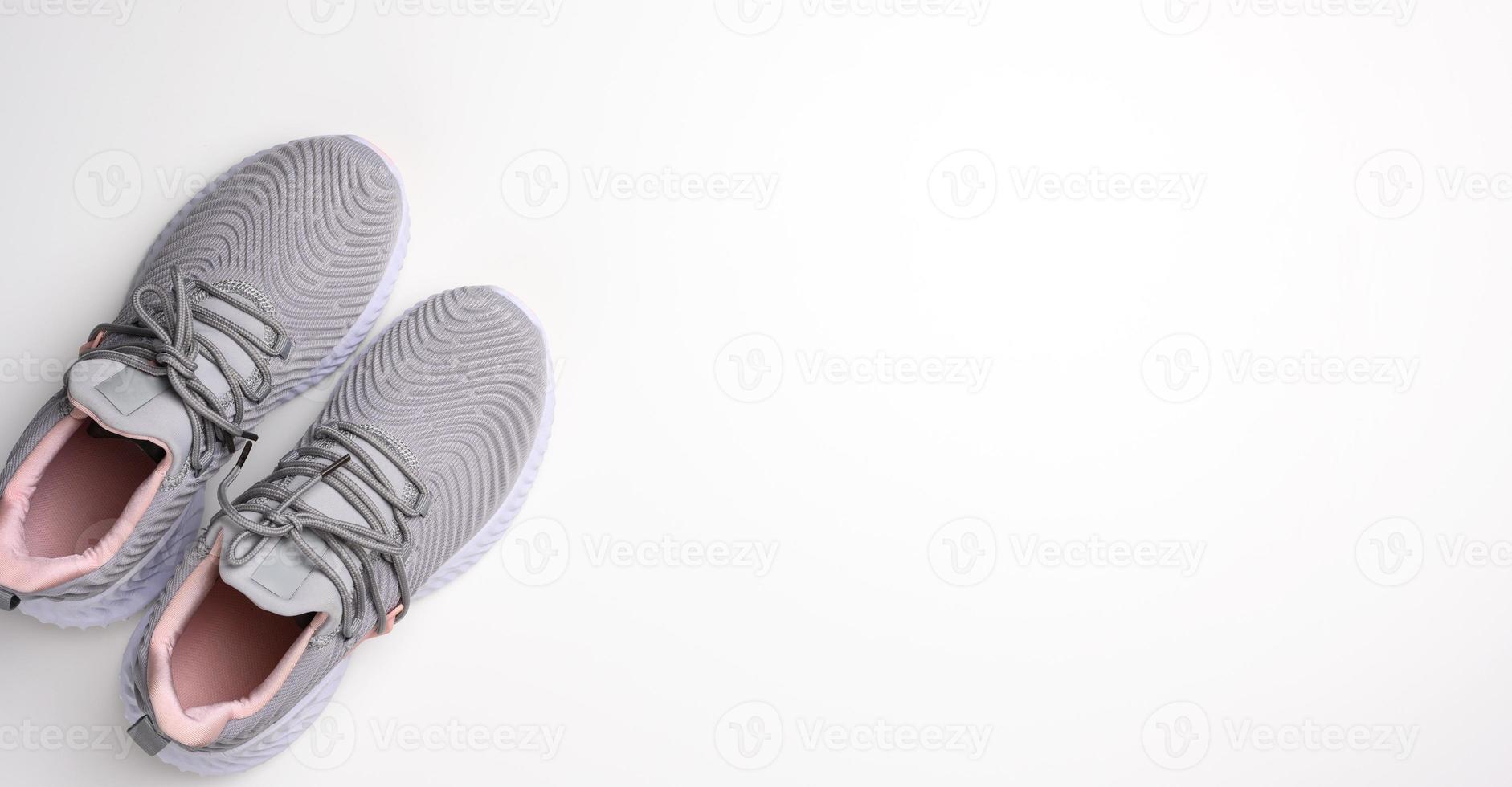 pair of gray textile sneakers on a white background, top view. Shoes for sports, jogging photo