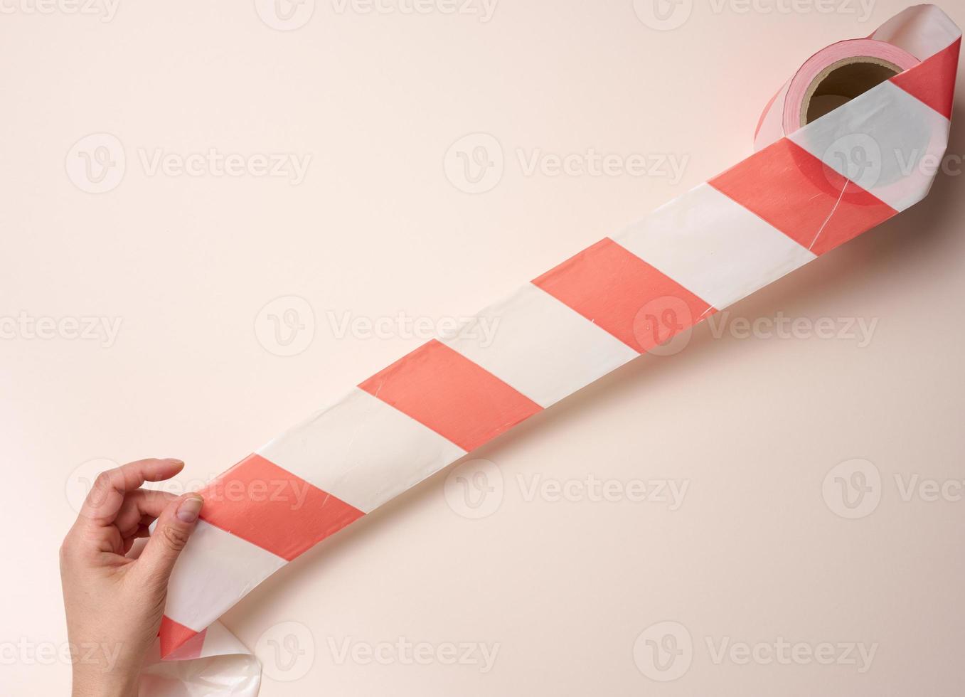 female hand holding a roll of protective tape on a beige background photo