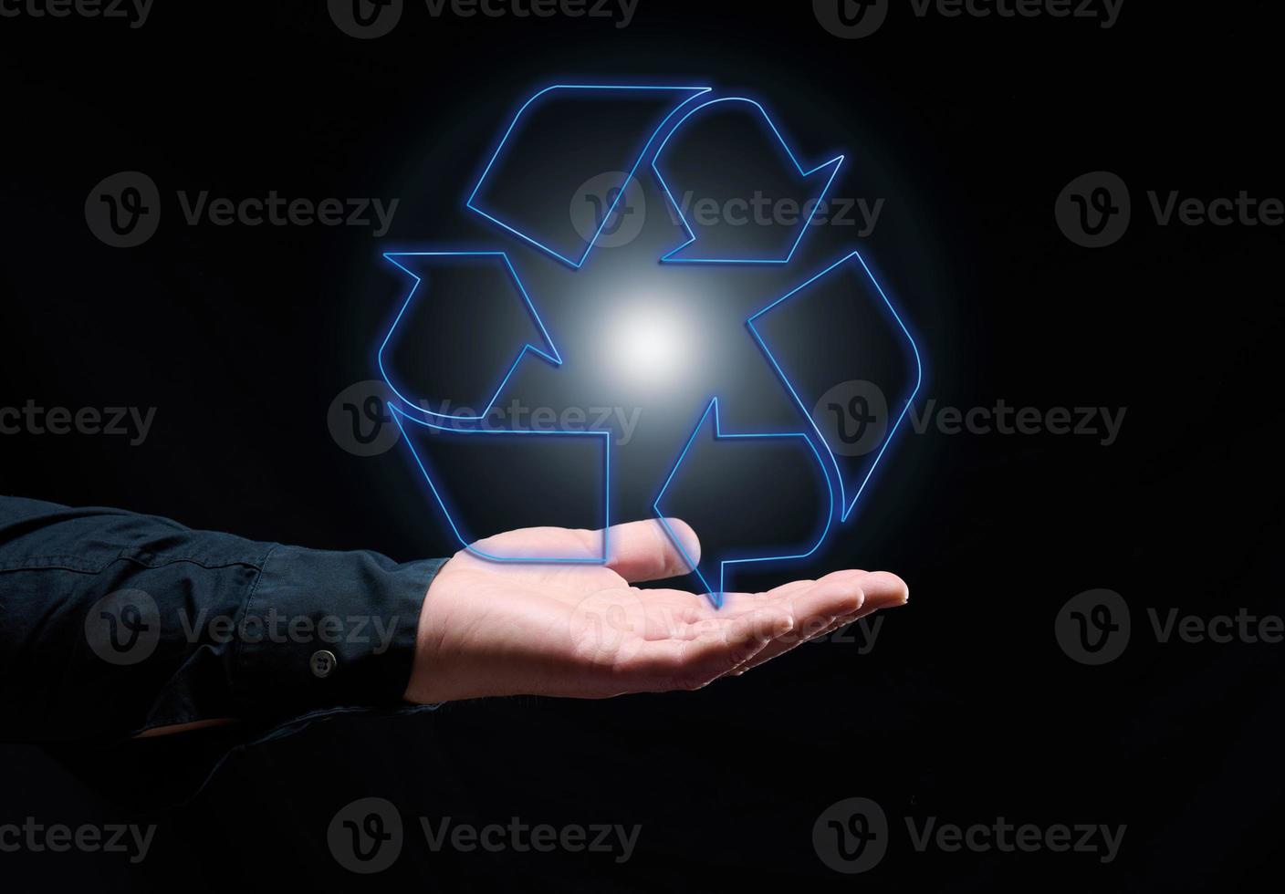 Blue glowing recycling sign floating above hand, sustainable development. Ecology and environment concept. photo